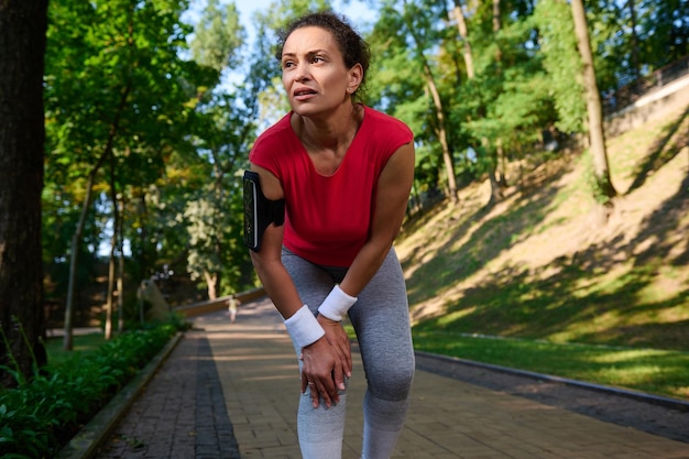Sportswoman holds her knee with her hands in pain after a
muscle injury during a workout on a treadmill the concept of sports
injury healthcare athlete running outdoor and suffering for leg
pain