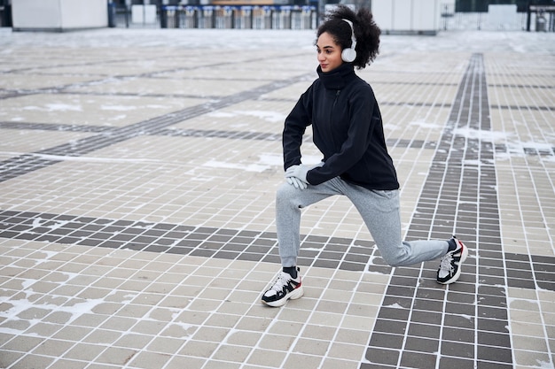 Sportswoman on a square doing the leg stretch