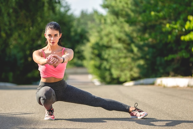 The sportswoman stretching on the alley