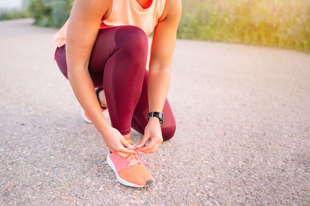 Sportswoman tying her shoelaces before the training.