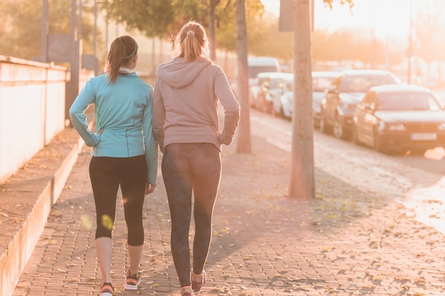 Photo sportswomen walking at sunset