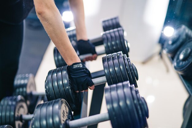 Sporttrainingsoefeningen met halters Jonge vrouw die traint in een fitnesscentrum