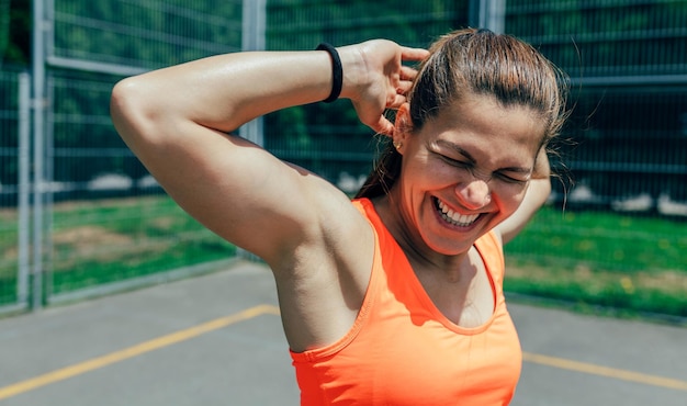 Sportvrouw doet arm strekt zich uit