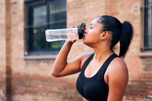 Sportvrouw drinkwater tijdens een training