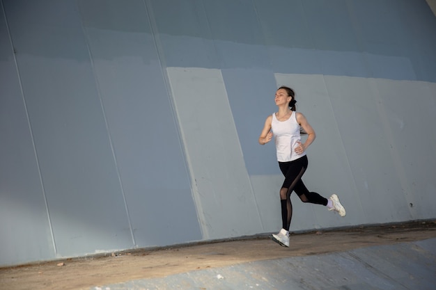 Sportvrouw loopt onder de brug