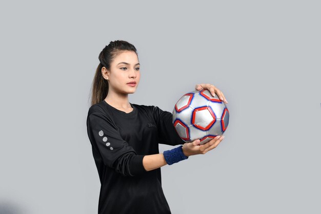 sportvrouwen die voetbal vasthouden en ernaar kijken indiaans pakistaans model