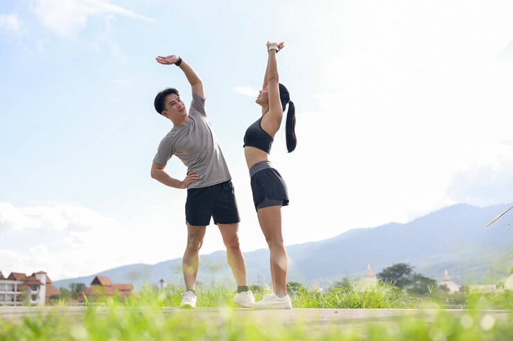 Photo 스포츠 의류 를 입은 스포츠 같은 아시아인 부부 가 공원 에서 함께 달리기 전 에 스트레칭 을 하고 워밍업 을 하고 있다