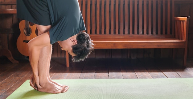 Sporty Asian man doing yoga while exercising on yoga mat Man Yoga Practice Pose Healthy living