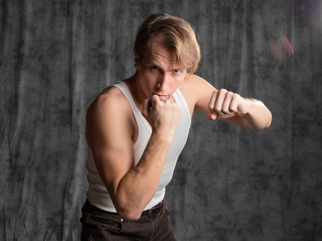 Photo a sporty and athletic guy in a white tshirt boxing a young man in a vintage outfit posing in a studi