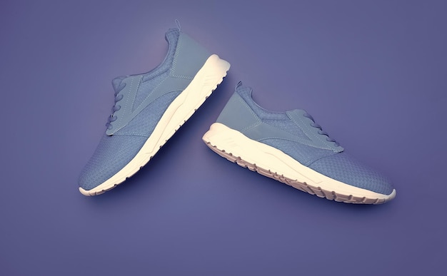 Sporty blue sneakers pair on blue background shoe store