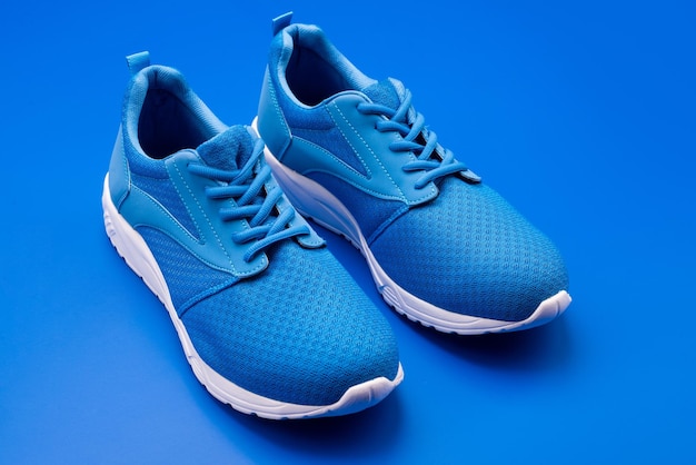 Sporty blue sneakers pair on blue background shoes