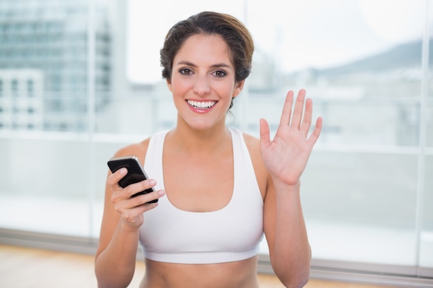 Sporty cheerful brunette waving