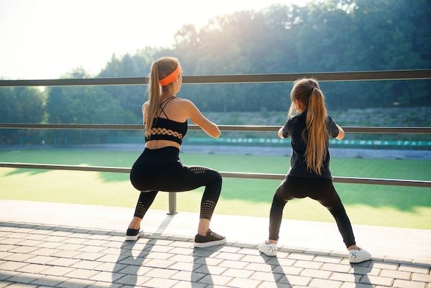 Le coppie sportive che fanno il salto si esercitano durante l'allenamento di forma fisica allo stadio all'aperto