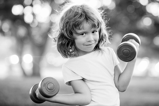 Sporty cute child with dumbbells kids sport and fitness health and energy healthy children lifestyle