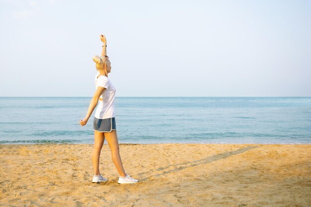 Sporty elderly woman training near sea Healthy and fitness lifestyle