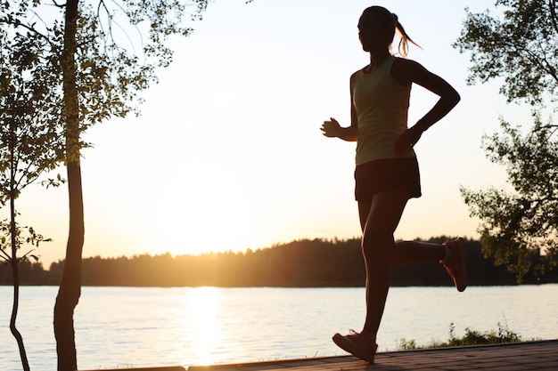 Sporty female jogger running and training outside in nature.