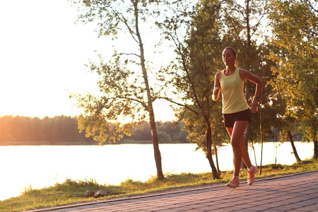 Photo sporty female jogger running and training outside in nature.