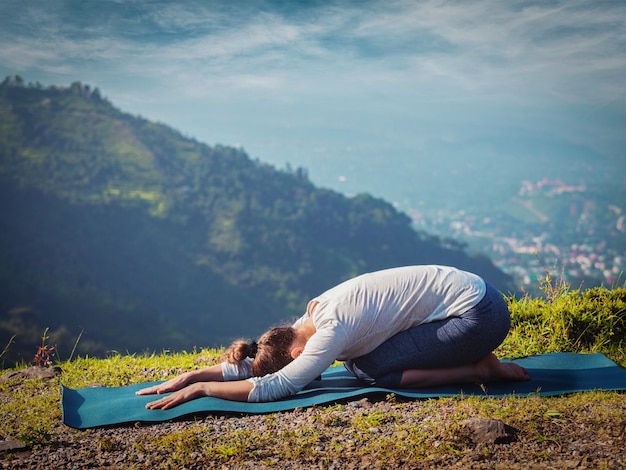 La donna in forma sportiva pratica lo yoga asana balasana