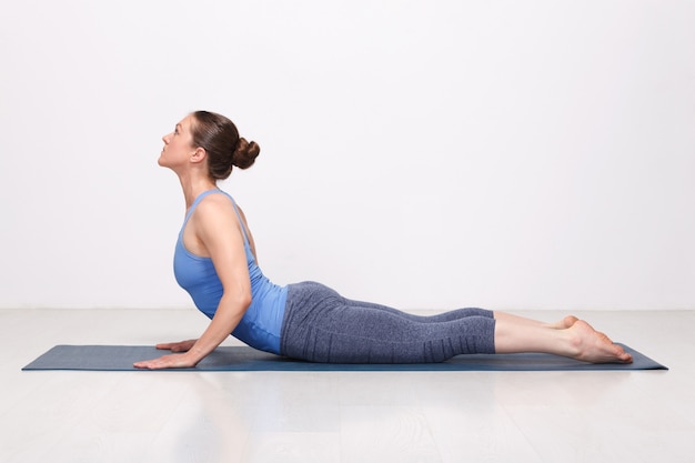 La donna yogini in forma sportiva pratica yoga asana bhujangasana