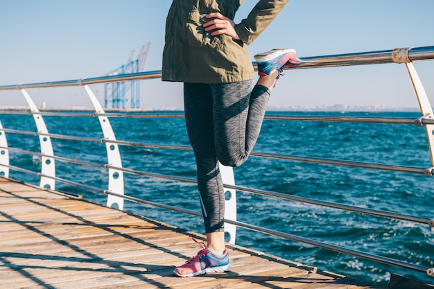 Sporty girl does exercises on the beach