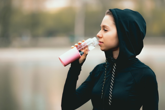 Photo sporty girl drinking water