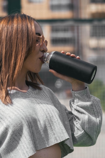 Sporty girl drinking water