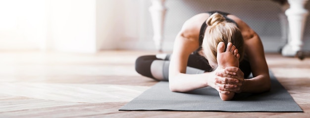 Sporty girl stretching touching her knees with forehead