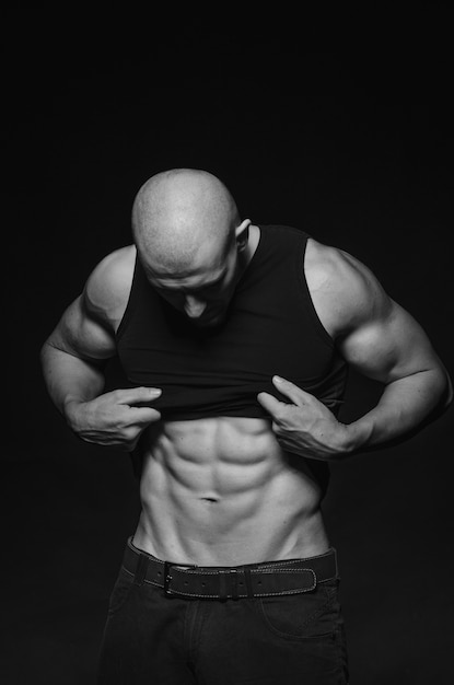 Sporty guy posing in the Studio on the space. Sports, beauty, black and white photography.