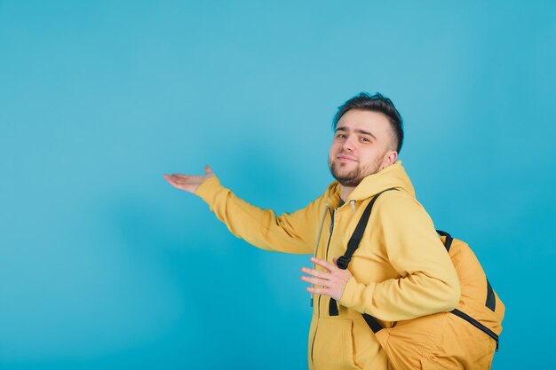 sporty guy in a yellow sweater with a yellow backpack on a blue background