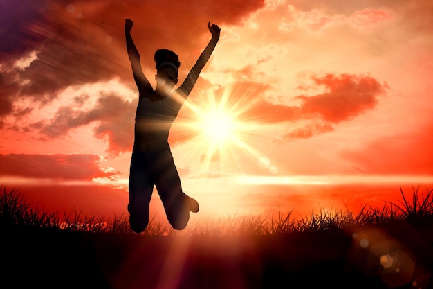 Sporty happy blonde jumping  against sunrise over grass