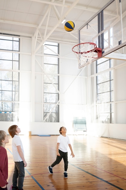 写真 ジムでバスケットボールをするスポーティな子供たち