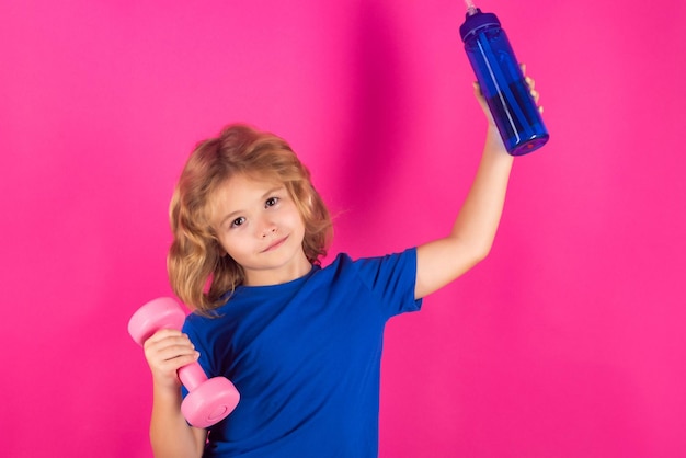 Sporty kids studio isolated portrait on pink red background Child workout Kid sport Child exercising with dumbbells Sporty child with dumbbell