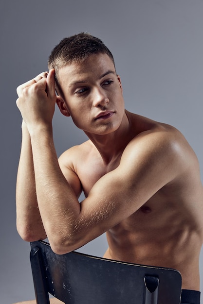 Sporty man attractive look pumped up body sitting on a chair