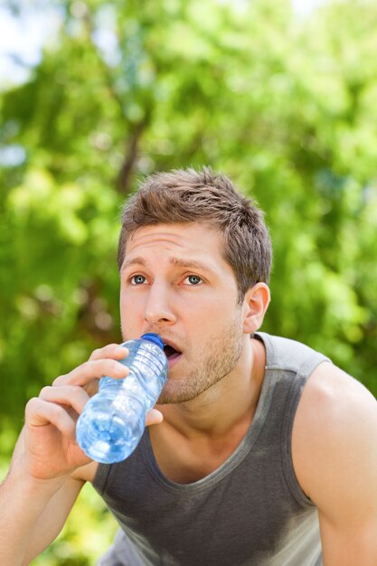 公園のスポーティな男の飲料水