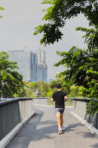 Foto uomo sportivo che fa jogging sul ponte in parco cittadino