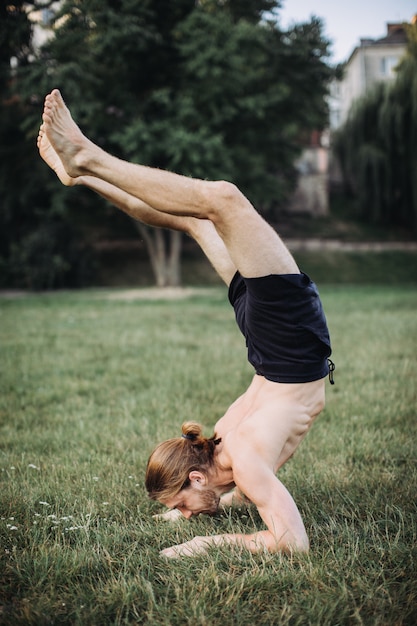 Sporty man practicing yoga outdoor