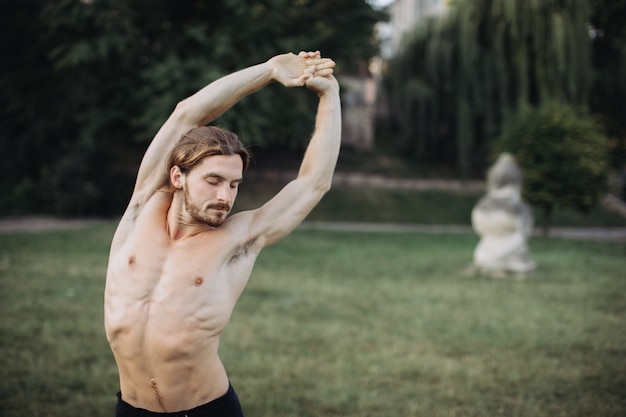 Sporty man practicing yoga outdoor