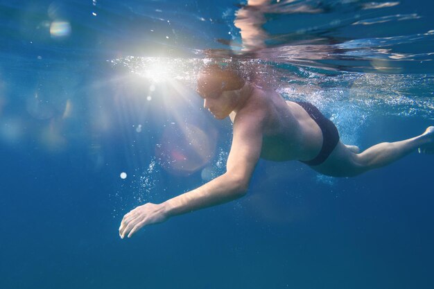 스포티 한 남자는 바다에서 빠르게 수영