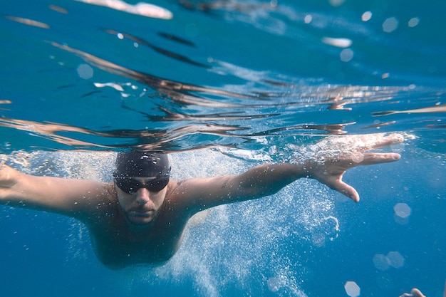 スポーティーな男は海で速く泳ぐ