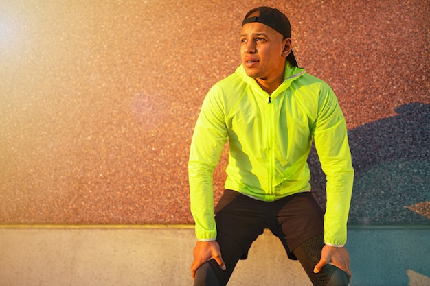 Sporty man taking a break while exercising outdoors Healthy lifestyle