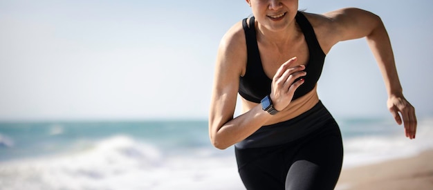 Sporty muscular female running on beach