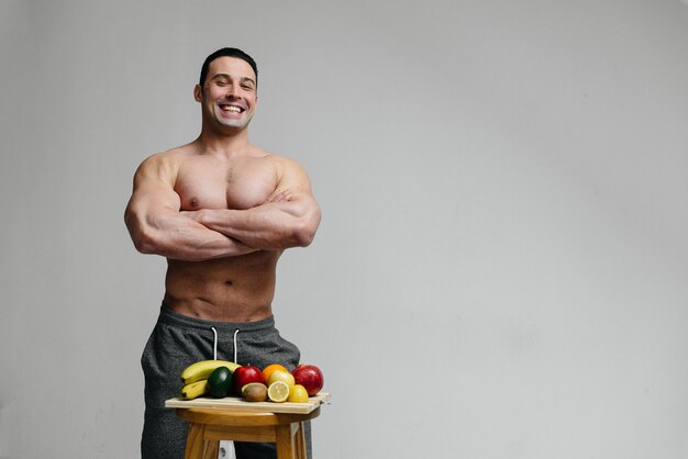 Sporty sexy guy posing  with bright fruits. Diet. Healthy diet