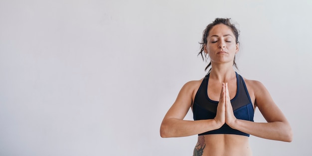 Sporty woman in Anjali Mudra pose