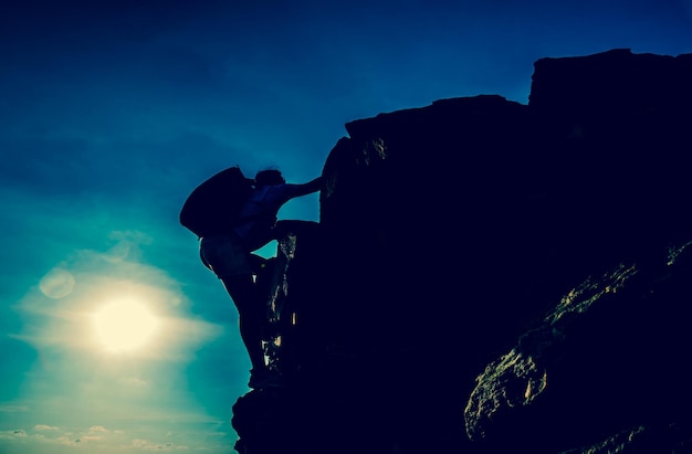 Photo sporty woman climbing on the cliff. success and goal concept. strong and healthy for outdoor activity.