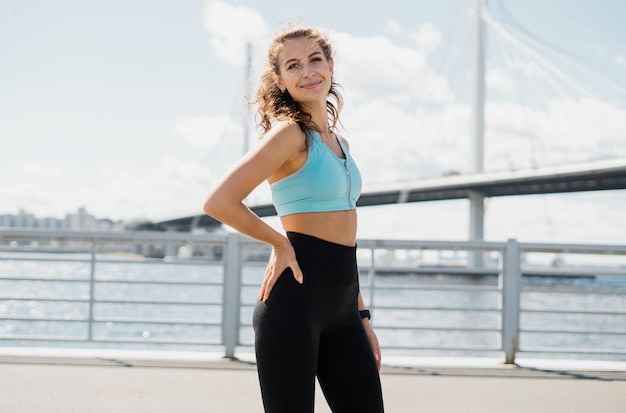 A sporty woman does fitness exercises on the street in the city