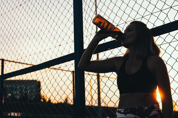 屋外でスポーティな女性の飲み水