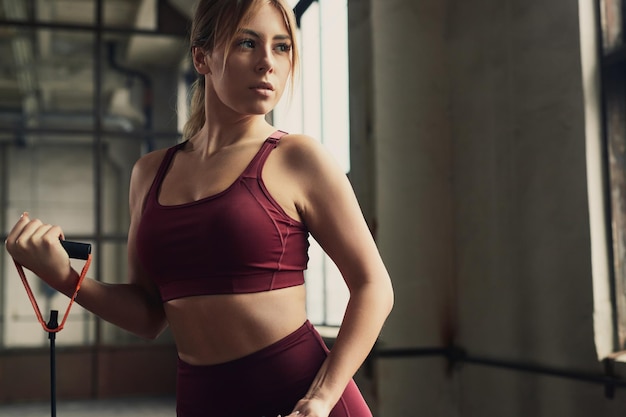 Sporty woman exercising with resistance rope