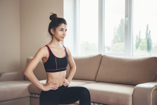 Sporty woman at home wearing sportswear is doing fitness during the lockdown