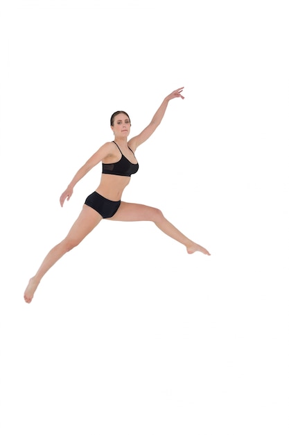 Sporty woman jumping on white background 