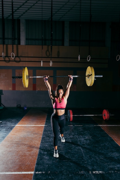 Photo sporty woman lifting barbell in gym